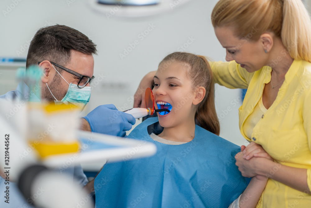 Dentist examining a patient's teeth in the dentist office Dentist examining a patient's teeth in the dentist office