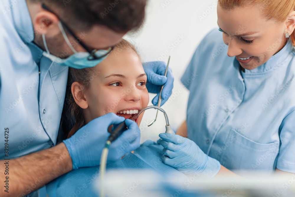Dentist examining a patient's teeth in the dentist office Dentist examining a patient's teeth in the dentist office