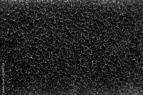 Household dishwashing sponge from reticulated foam, texture, black background