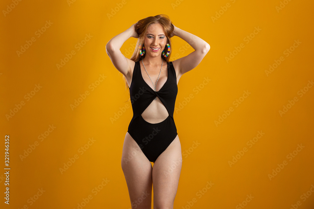 Portrait of beautiful cheerful redhead blonde girl smiling laughing looking at camera over yellow background.