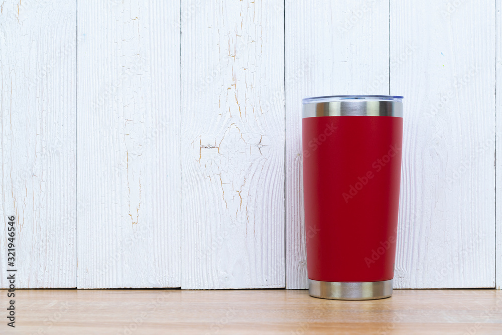 Red colour stainless steel tumbler or cold and hot storage cup on wood. Red colour stainless steel tumbler or cold and hot storage cup on wood.