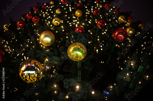 Christmas balls on the Christmas tree. Decoration for the new year. The tradition of decorating a tree and hanging glass spheres on the branches of a spruce. Festive background for postcards.
