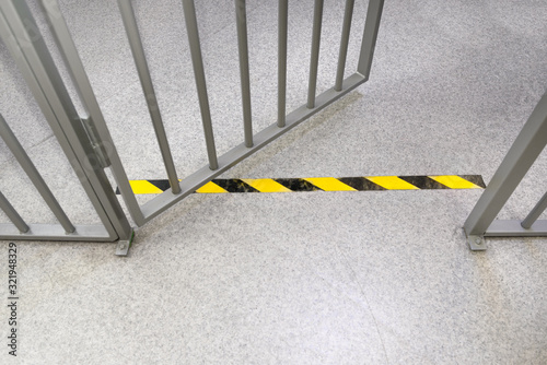 Metal bars in prison. Opened jail cell door. The lock an steel bobble handle closeup . Safety line. Do not cross!