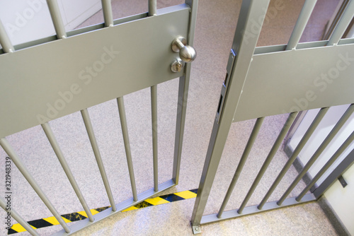 Metal bars in prison. Opened jail cell door. The lock an steel bobble handle closeup . Safety line. Do not cross!