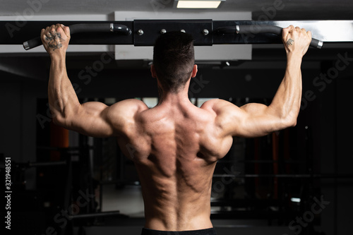 Male Athlete Doing Pull Ups © Jale Ibrak