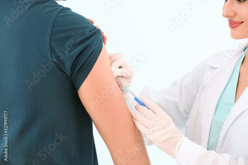 Doctor vaccinating young ma...