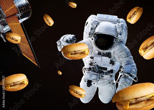 Satellite telescope near to astronaut with burgers somewhere in space. Science fiction wallpaper. Elements of the image were furnished by NASA photo