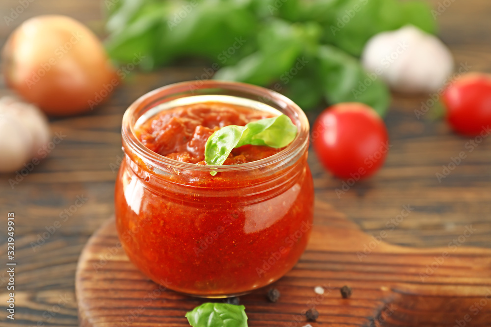 Jar with tomato sauce on table Jar with tomato sauce on table
