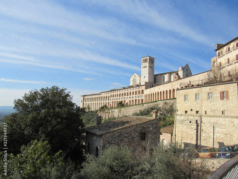 View of the Basilica of Saint Francis of Assisi on the hill in Assisi, Italy on a sunny day