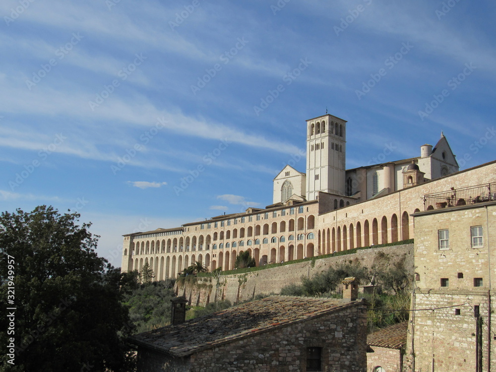 View of the Basilica of Saint Francis of Assisi on the hill in Assisi, Italy on a sunny day