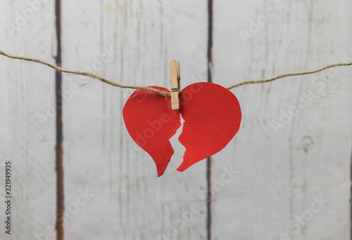 Red cardboard heart hung with wooden clamp