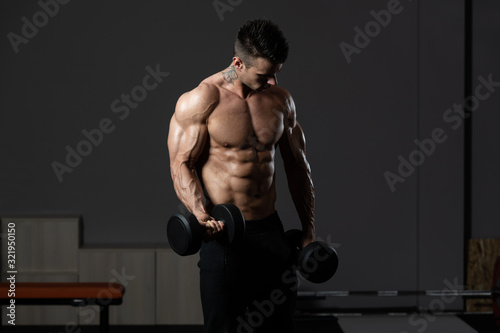 Man With Dumbbells Exercising Biceps © Jale Ibrak