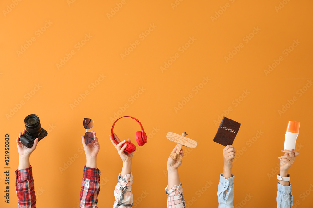 Many hands with travel items on color background - obrazy, fototapety, plakaty 