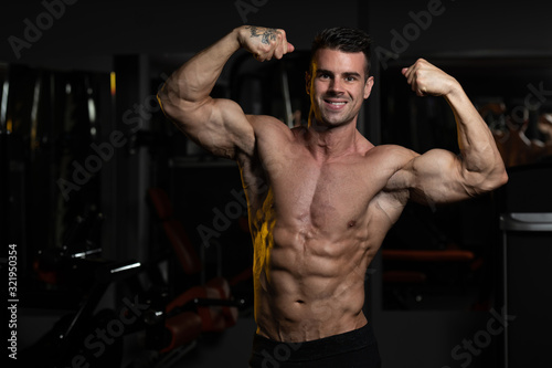 Bodybuilder Fitness Model Posing Double Biceps After Exercises