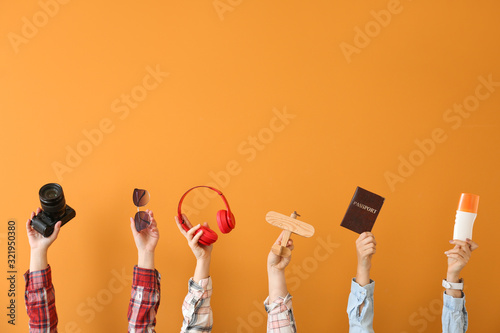 Many hands with travel items on color background photo