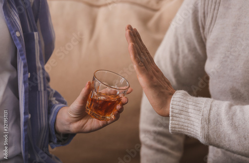 Man refusing to drink whiskey at home. Concept of alcoholism