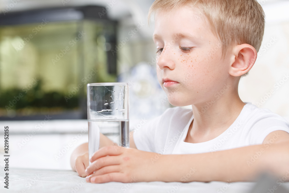 little boy in kitchen with glass of clean water little boy in kitchen with glass of clean water