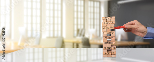 risk management concept. pull the risk management block through the wooden block tower photo