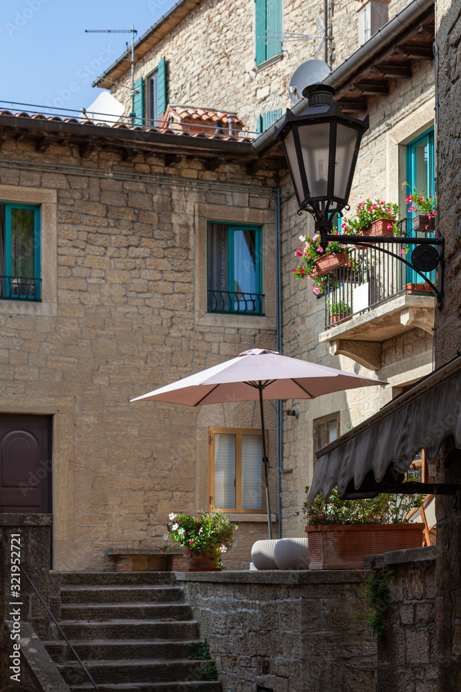 Cozy courtyard on an old street. In the foreground is a vintage street lamp.
