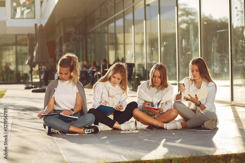 Students in a park. Girls on a students campus. Friends with a tablet.