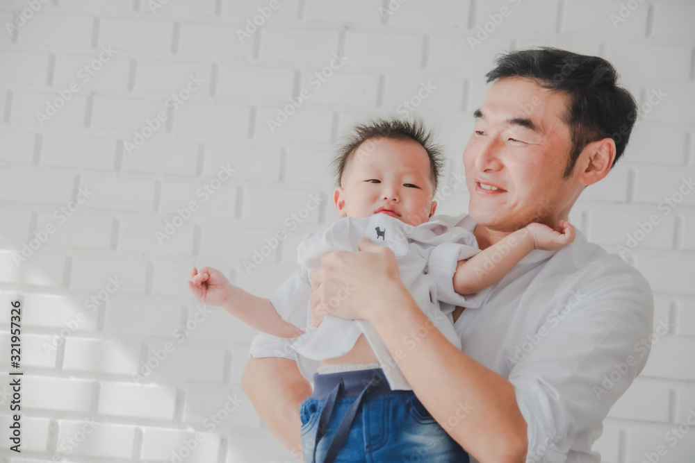 Asian Japanese Family father mother son wearing white shirt carrying child posing for photo on bedroom in white room.To keep memories moment cuteness of son in childhood lifestyle happy Asian Japanese Family father mother son wearing white shirt carrying child posing for photo on bedroom in white room.To keep memories moment cuteness of son in childhood lifestyle happy