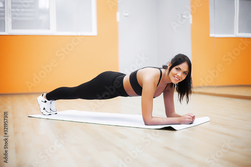Young attractive woman doing exercises in fitness gym.