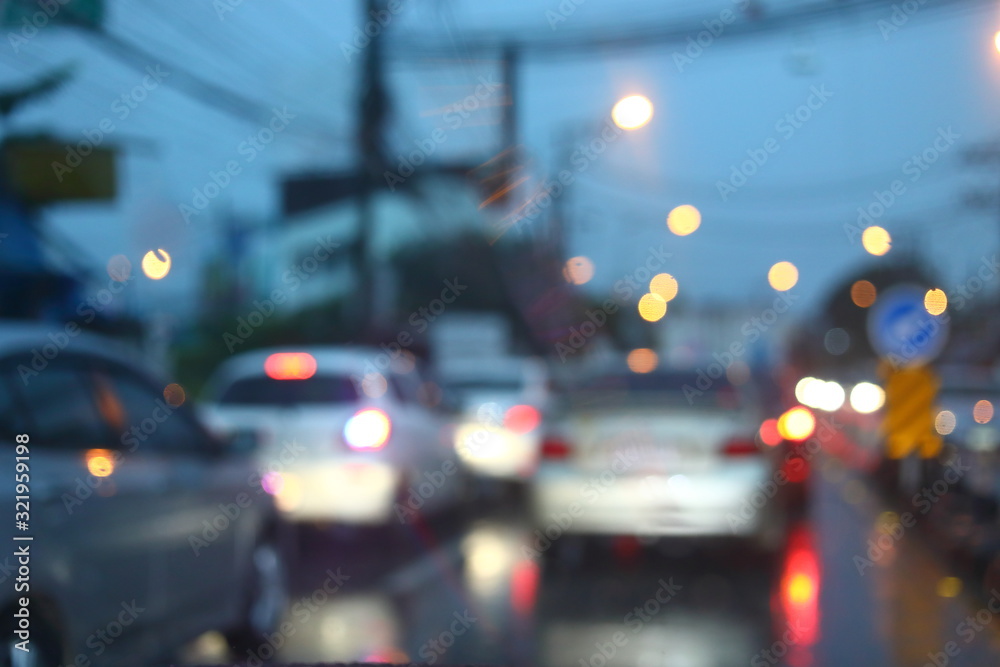 traffic jam on night road city with storm rainy day weather, car driving on street town with water rain drop on windshield outside of bad view