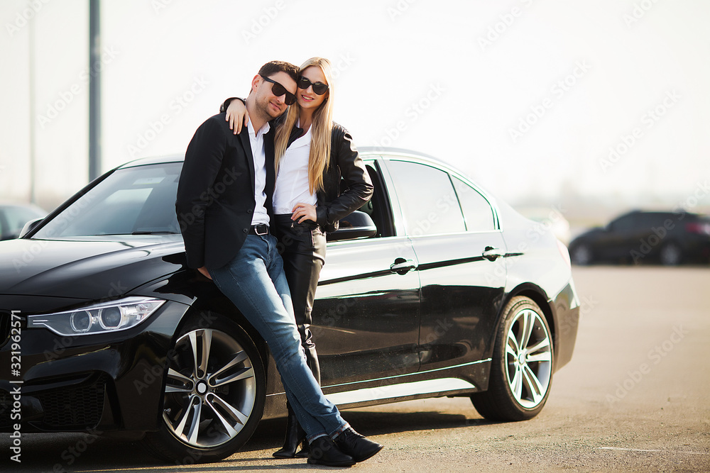 Happy young couple chooses and buying a new car for the family