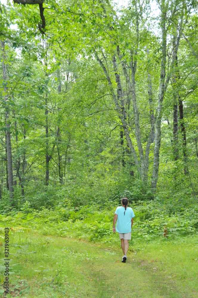Woman taking a hike through the forest Woman taking a hike through the forest
