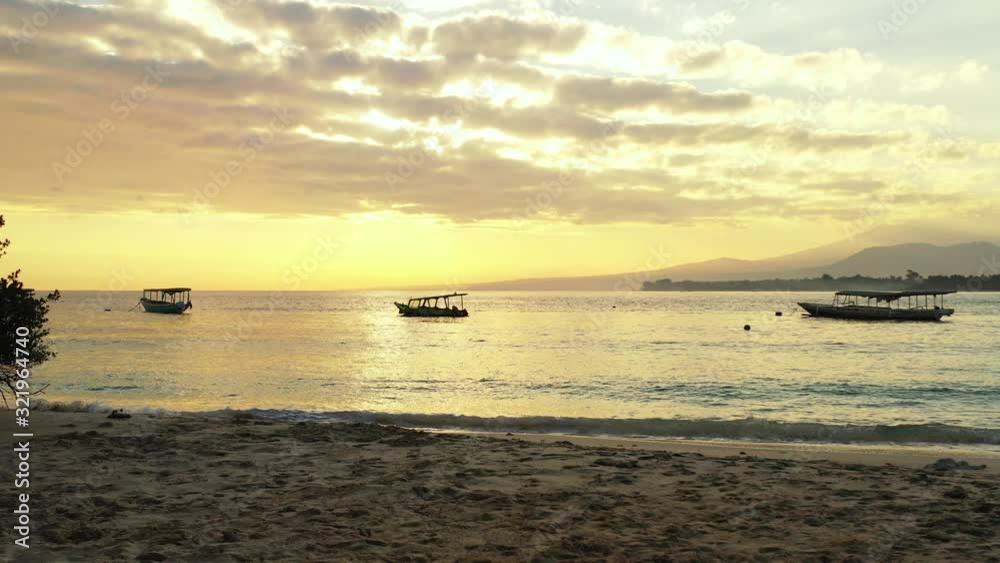 A beautiful afternoon with the golden sun setting and glistening in the shallow waves of a tropical beach island A beautiful afternoon with the golden sun setting and glistening in the shallow waves of a tropical beach island