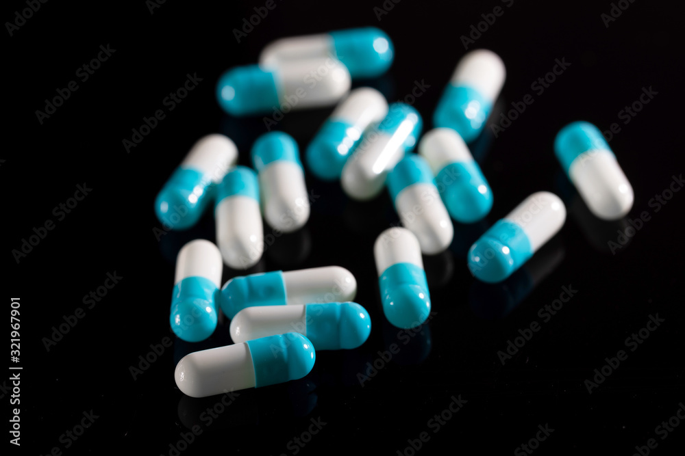 Pharmacy background on a dark table. Levitation pills. Tablets on a dark background which falling down. Pills. Medicine and healthy. Close up of capsules. Pills falling on black background