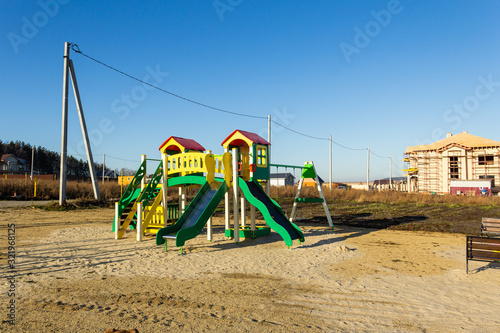 Wallpaper Mural playground in the cottage village under construction. At the background the village. Autumn, sunny day Torontodigital.ca