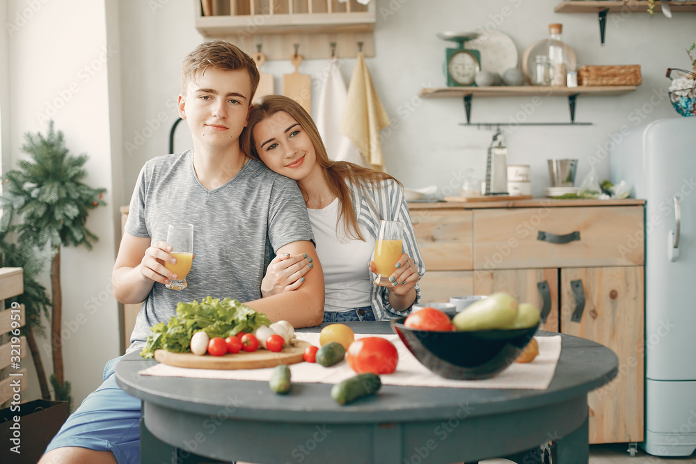 Woman in a kitchen. Blonde in a white t-shirt. Couple with vegetables Woman in a kitchen. Blonde in a white t-shirt. Couple with vegetables