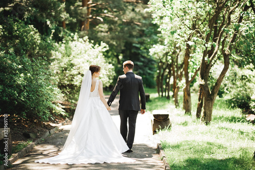 Happy wedding couple walking in a botanical park