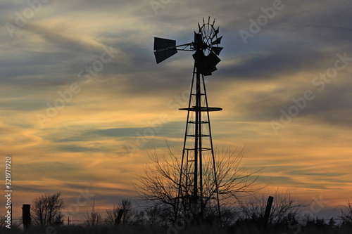 Kansas Windmill at Sunset with a colorful sky out in the country north of Hutchinson Kansas USA. photo