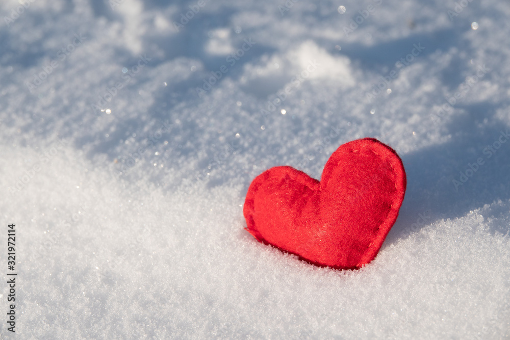 Fototapeta premium Red hearts in glittering snow with shallow depth of field