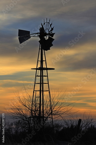 Kansas Windmill at Sunset with a colorful sky out in the country north of Hutchinson Kansas USA.
