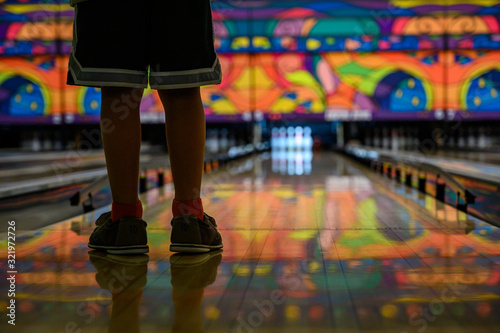 Legs of young child at the top of a bowling lane