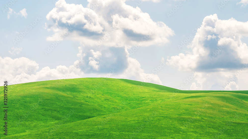 green hills and fields and blue sky with clouds. concept of serenity.