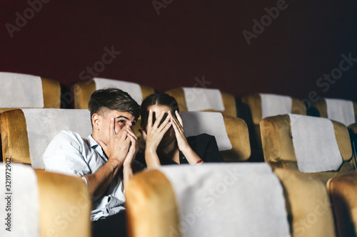 Caucasian white man and woman see thriller movie.