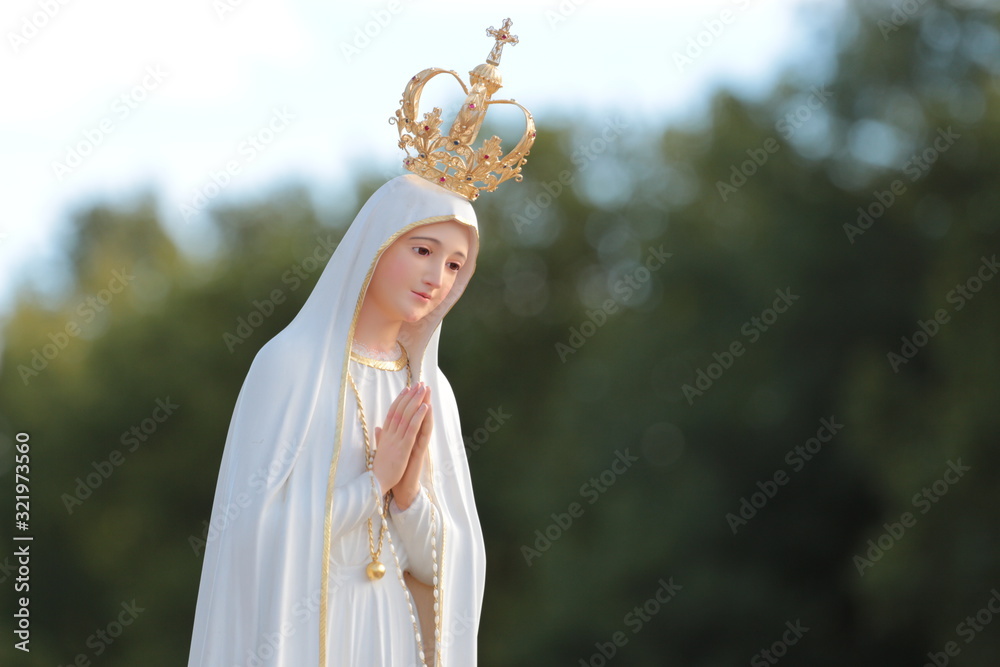 Beautiful statue of the Virgin Mary praying with her hands joined ,with a crown. Our Lady of Fatima.  Paray-le-Monial, France.