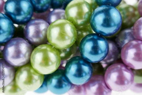 colored pearls close-up. pearl beads background.blue, purple, green and pink beads texture.Beautiful decoration background in cold colors.