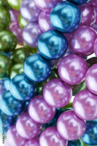 pearls close-up. pearl beads round background.blue, purple, green and pink beads texture.Beautiful decoration background in cold colors.