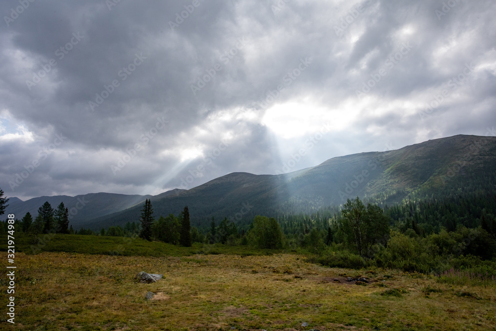 Mountain landscape. A ray of the sun breaks through the clouds