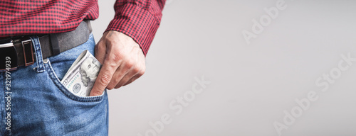 Man putting dollars into the pocket.