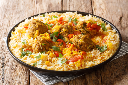 Kofta Chalao Recipe for Afghan meatballs in spicy sauce with yellow peas served with basmati rice close-up in a plate. horizontal