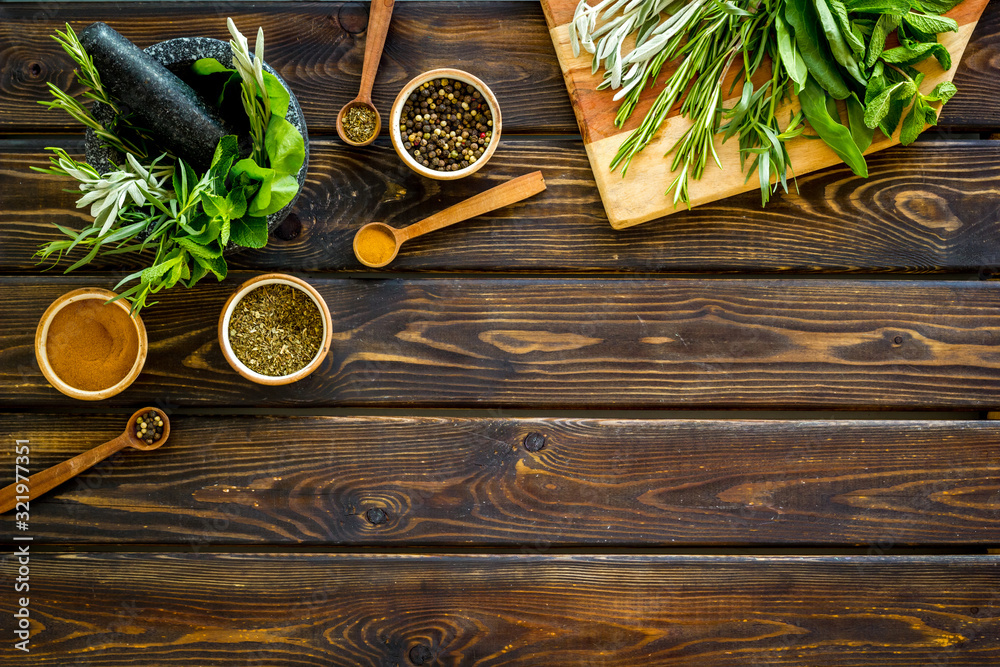 Making spices. Herbs in motar and dry flavorings on dark wooden desk top-down copy space Making spices. Herbs in motar and dry flavorings on dark wooden desk top-down copy space