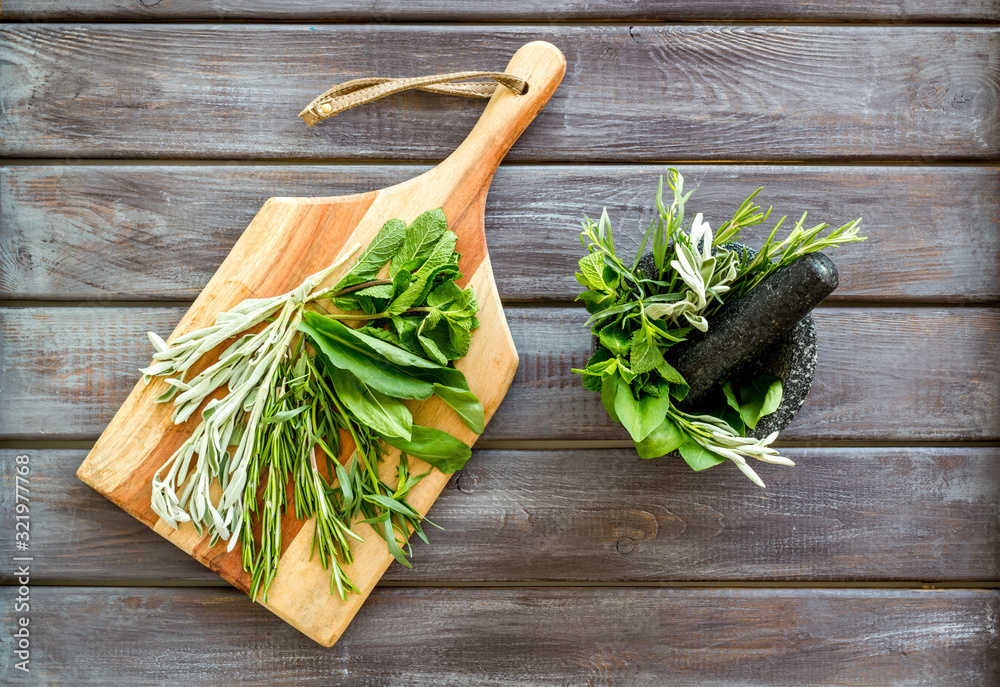 Make seasoning and condiments. Herbs in mortar on dark wooden background top-down Make seasoning and condiments. Herbs in mortar on dark wooden background top-down
