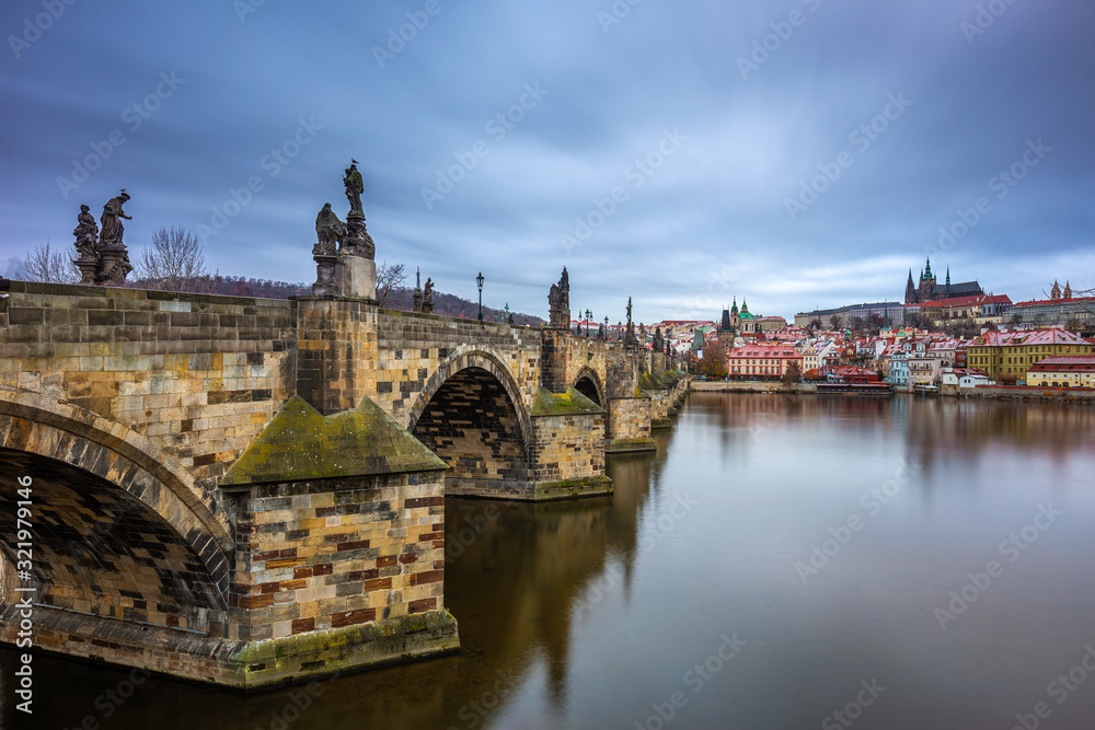 Prague, Czech Republic - The world famous Charles Bridge (Karluv most) with River Vltava and St. Vitus Cathedral on a cludy winter morning