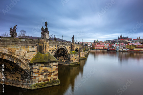 Prague, Czech Republic - The world famous Charles Bridge (Karluv most) with River Vltava and St. Vitus Cathedral on a cludy winter morning